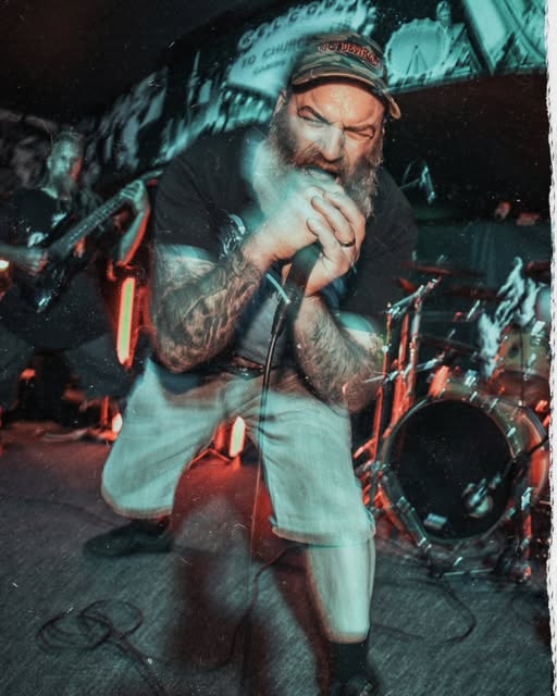 A vocalist leans into the microphone during a close-packed live gig, photographed by Peter Iti / Koda400